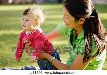 Baby girl being held by mother View Large Photo Image Stock Photograph - Baby girl being held by mother. Fotosearch