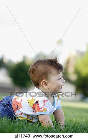 Baby girl crawling in grass View Large Photo Image Stock Photo - Baby girl crawling in grass. Fotosearch