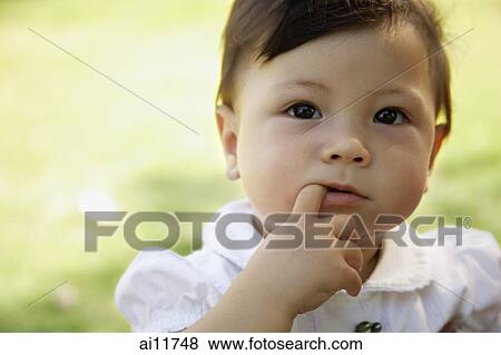 Baby girl with finger in mouth, looking at camera View Large Photo Image Stock Photo - Baby girl with finger in mouth, looking at camera. Fotosearch