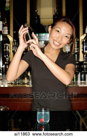 Stock Image - Bartender with cocktail mixer. Fotosearch