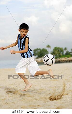 Boy playing with soccer ball on beach View Large Photo Image Picture - Boy playing with soccer ball on beach. Fotosearch