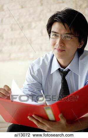 Businessman holding folder, looking away View Large Photo Image Stock Image - Businessman holding folder, looking away. Fotosearch