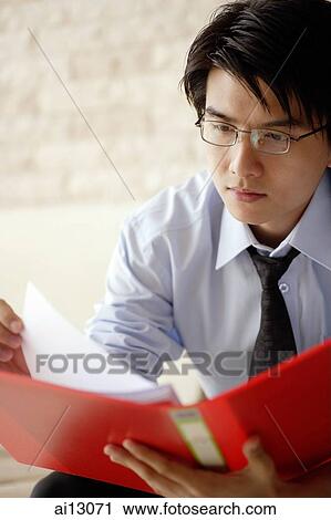 Businessman looking at documents View Large Photo Image Stock Image - Businessman looking at documents. Fotosearch