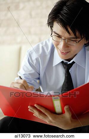 Businessman looking at documents, smiling View Large Photo Image Stock Image - Businessman looking at documents, smiling. Fotosearch