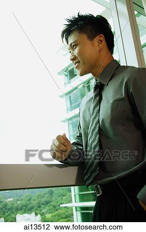 Businessman looking out window, smiling View Large Photo Image Stock Image - Businessman looking out window, smiling. Fotosearch