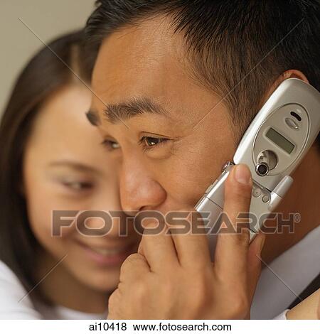 Businessman on mobile phone, woman in the background View Large Photo Image Stock Photo - Businessman on mobile phone, woman in the background. Fotosearch