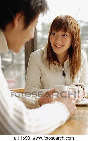 Stock Image - Couple at a cafe, talking, face to face. Fotosearch