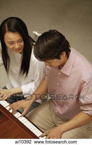 Couple at a piano, high angle view View Large Photo Image Stock Image - Couple at a piano, high angle view. Fotosearch