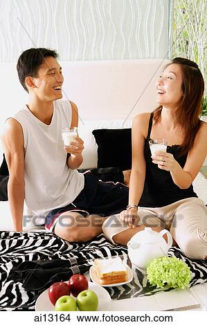 Couple at home, both holding glasses of milk View Large Photo Image Picture - Couple at home, both holding glasses of milk. Fotosearch