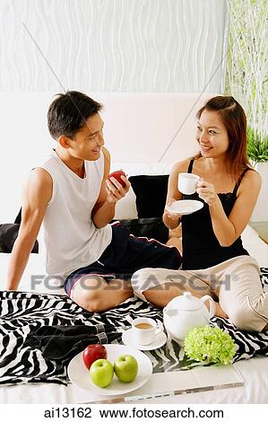 Stock Image - Couple at home, eating. Fotosearch