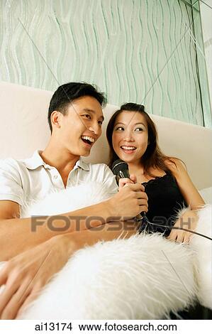 Couple at home, holding microphone, singing View Large Photo Image Picture - Couple at home, holding microphone, singing. Fotosearch