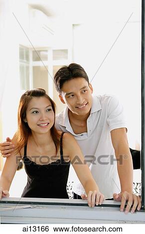 Couple at home, looking out window View Large Photo Image Stock Photograph - Couple at home, looking out window. Fotosearch