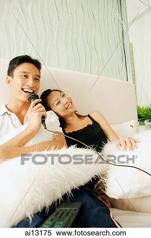 Couple at home, man holding microphone, singing View Large Photo Image Stock Photography - Couple at home, man holding microphone, singing. Fotosearch