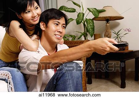 Couple at home, man holding remote control View Large Photo Image Stock Photo - Couple at home, man holding remote control. Fotosearch