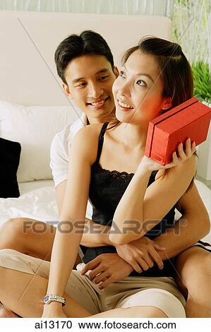 Couple at home, man hugging woman, woman holding box View Large Photo Image Stock Image - Couple at home, man hugging woman, woman holding box. Fotosearch