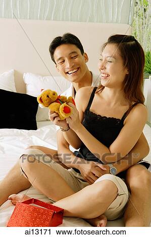 Couple at home, man hugging woman, woman holding toy View Large Photo Image Stock Image - Couple at home, man hugging woman, woman holding toy. Fotosearch