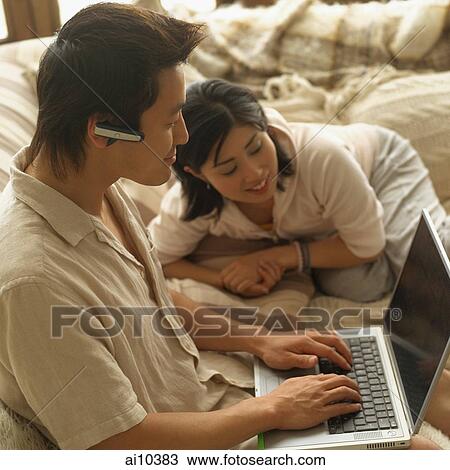 Couple at home, man using laptop View Large Photo Image Stock Image - Couple at home, man using laptop. Fotosearch