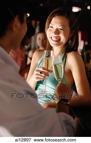 Couple at night club, toasting with champagne glasses View Large Photo Image Stock Photo - Couple at night club, toasting with champagne glasses. Fotosearch