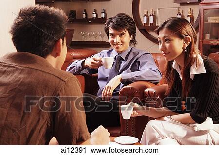 Couple having coffee, facing another man View Large Photo Image Stock Image - Couple having coffee, facing another man. Fotosearch