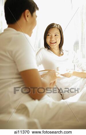Couple having coffee, sitting on sofa View Large Photo Image Stock Image - Couple having coffee, sitting on sofa. Fotosearch