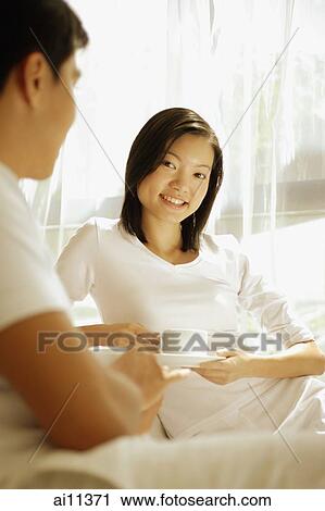 Couple having coffee, sitting on sofa, woman looking at camera View Large Photo Image Stock Image - Couple having coffee, sitting on sofa, woman looking at camera. Fotosearch