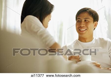 Couple having coffee, sitting on sofa. View Large Photo Image Stock Photo - Couple having coffee, sitting on sofa.. Fotosearch