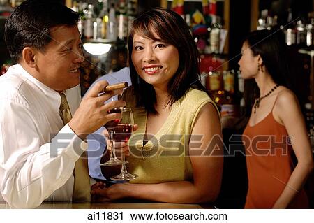 Couple having drinks, woman looking at camera View Large Photo Image Stock Image - Couple having drinks, woman looking at camera. Fotosearch
