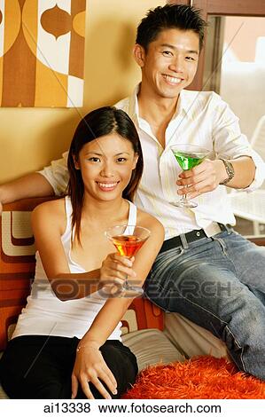 Couple, holding and raising their drinks View Large Photo Image Stock Photo - Couple, holding and raising their drinks. Fotosearch