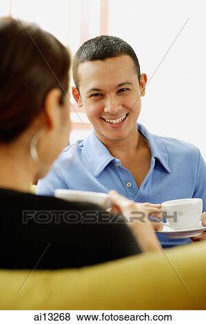 Couple holding cup and saucer, man facing camera View Large Photo Image Stock Photo - Couple holding cup and saucer, man facing camera. Fotosearch
