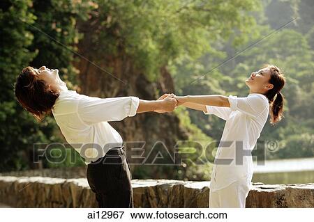 Couple holding hands, looking up View Large Photo Image Stock Photo - Couple holding hands, looking up. Fotosearch