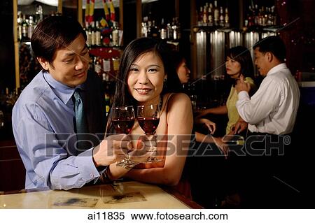 Couple holding wine glasses, woman looking at camera View Large Photo Image Stock Photography - Couple holding wine glasses, woman looking at camera. Fotosearch