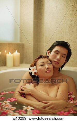 Couple hugging in tub, flowers floating around View Large Photo Image Stock Photo - Couple hugging in tub, flowers floating around. Fotosearch