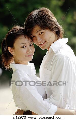 Couple hugging, looking at camera View Large Photo Image Stock Image - Couple hugging, looking at camera. Fotosearch