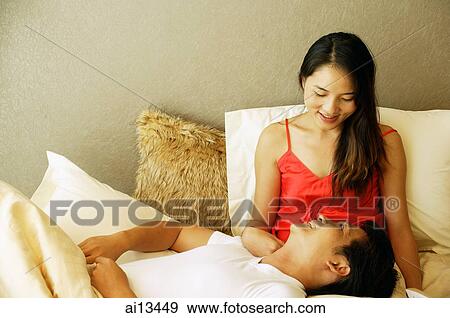 Couple in bed, man lying on woman's lap View Large Photo Image Stock Photo - Couple in bed, man lying on woman's lap. Fotosearch