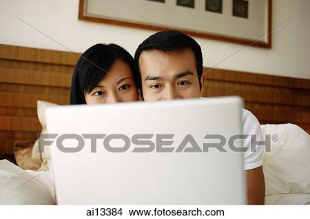 Couple in bed using laptop View Large Photo Image Picture - Couple in bed using laptop. Fotosearch
