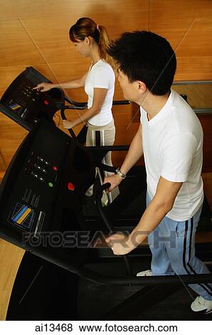 Couple in gym, on treadmill View Large Photo Image Stock Photo - Couple in gym, on treadmill. Fotosearch