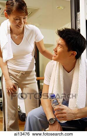 Couple in gym, resting, man looking up at woman View Large Photo Image Stock Photograph - Couple in gym, resting, man looking up at woman. Fotosearch