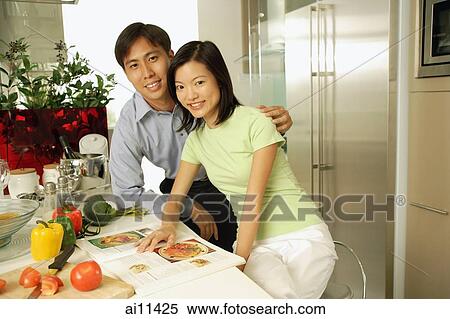Couple in kitchen, looking at camera View Large Photo Image Stock Photography - Couple in kitchen, looking at camera. Fotosearch