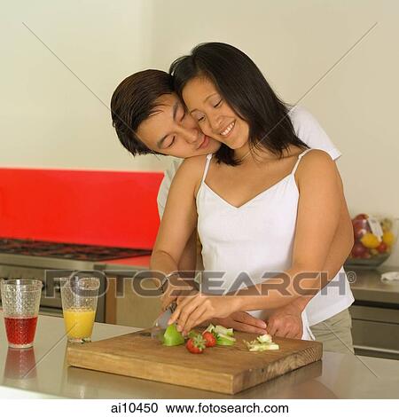 Couple in kitchen, man hugging woman from behind View Large Photo Image Stock Image - Couple in kitchen, man hugging woman from behind. Fotosearch