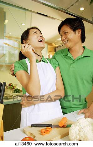 Couple in kitchen, man with arm around woman View Large Photo Image Stock Image - Couple in kitchen, man with arm around woman. Fotosearch