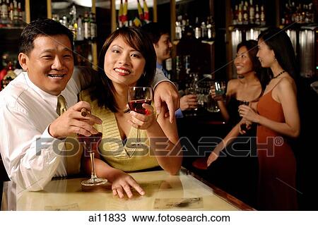Couple looking at camera, holding wine glasses View Large Photo Image Stock Image - Couple looking at camera, holding wine glasses. Fotosearch