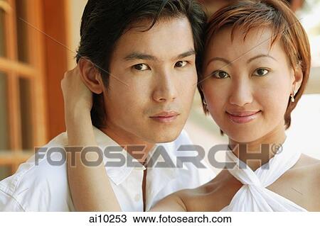 Stock Image - Couple looking at camera, portrait. Fotosearch