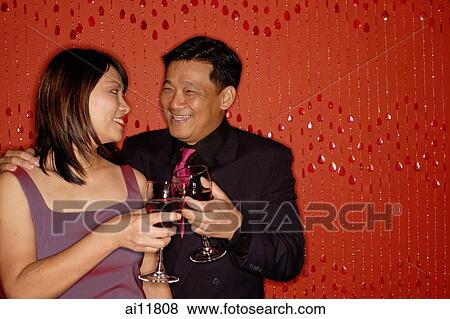 Couple looking at each other, holding wine glasses View Large Photo Image Stock Photo - Couple looking at each other, holding wine glasses. Fotosearch
