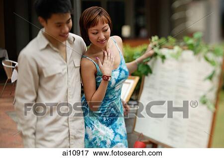 Couple looking at menu, smiling View Large Photo Image Stock Photo - Couple looking at menu, smiling. Fotosearch