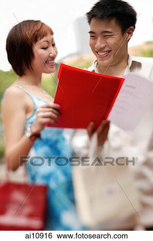 Couple looking at menu, smiling View Large Photo Image Stock Photograph - Couple looking at menu, smiling. Fotosearch