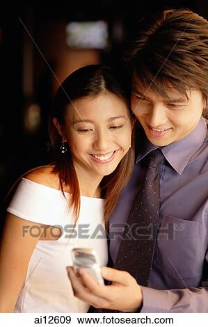 Couple looking at mobile phone View Large Photo Image Stock Photo - Couple looking at mobile phone. Fotosearch