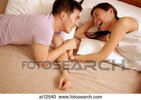 Couple lying in bed, looking at each other View Large Photo Image Stock Image - Couple lying in bed, looking at each other. Fotosearch