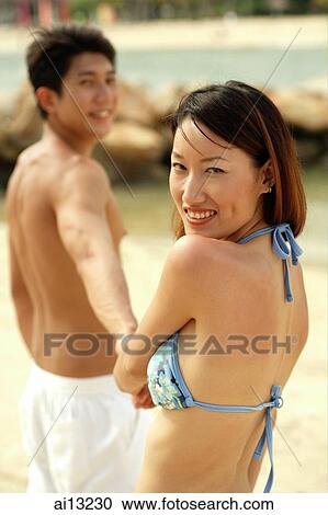 Couple on beach, woman turning to look at camera View Large Photo Image Stock Image - Couple on beach, woman turning to look at camera. Fotosearch