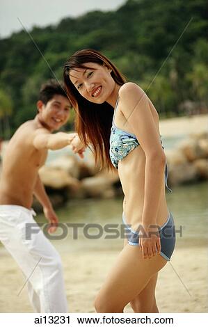 Couple on beach, woman turning to look at camera, man pulling her View Large Photo Image Stock Image - Couple on beach, woman turning to look at camera, man pulling her. Fotosearch