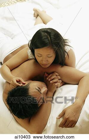 Couple on bed, high angle view View Large Photo Image Stock Image - Couple on bed, high angle view. Fotosearch